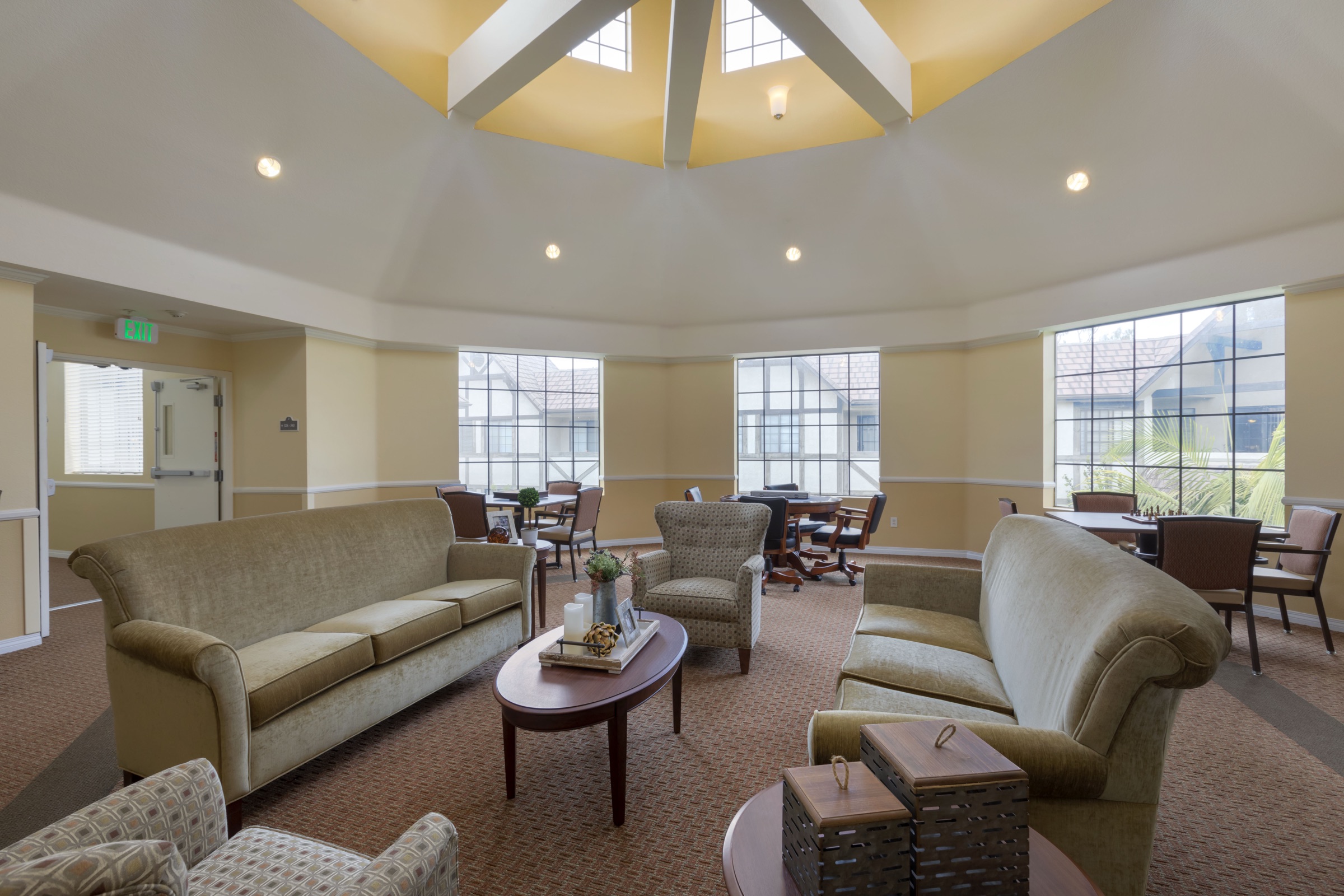 The community living room, with sofas, armchairs and tall windows