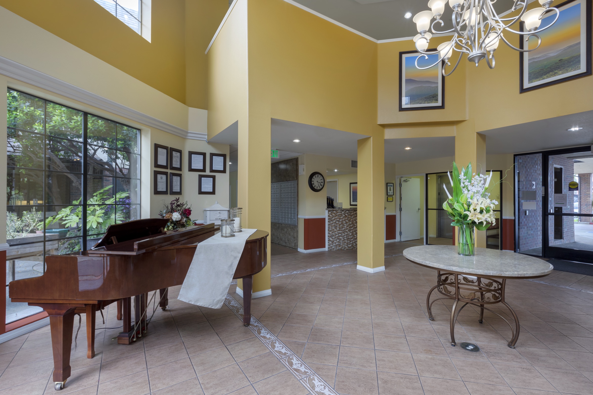 The foyer, with a piano, seating and tall windows